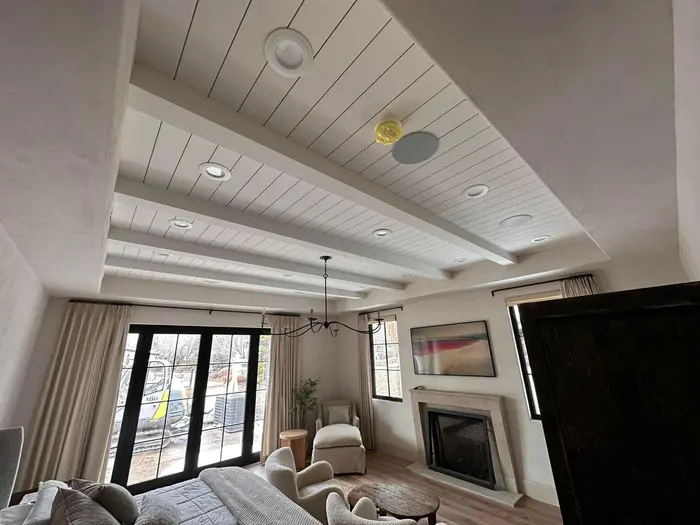 A cozy living space showcasing a beautiful ceiling design with natural light streaming in.