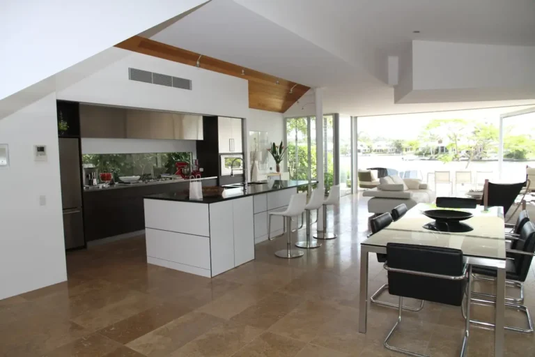 Minimalist kitchen interior with white cabinetry and a black countertop.