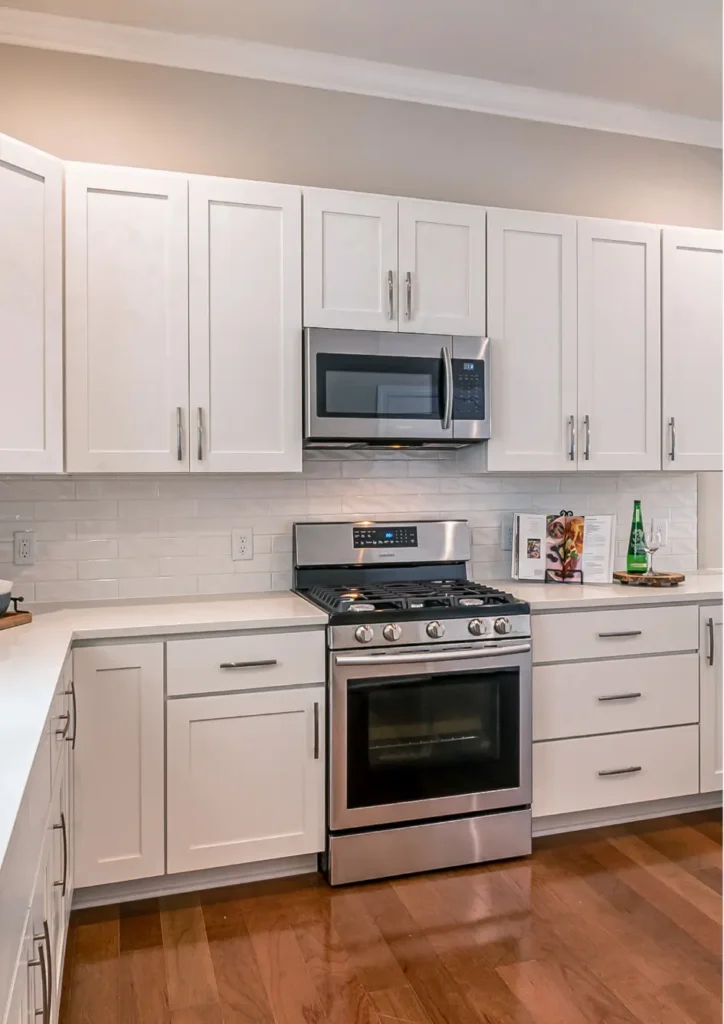 Sleek kitchen design with a gas stove and microwave above.